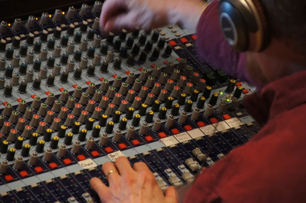 An engineer working at the console with headphones on