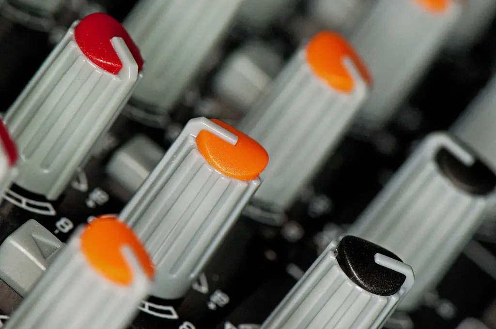 Macro detail of amber-capped rotary controls on an outboard unit